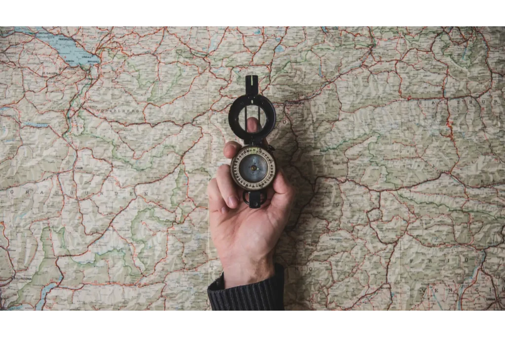 地図の上でコンパスを掲げる画像